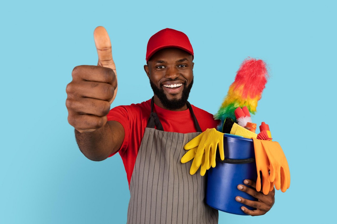 cleaning-services-black-cleaner-man-holding-basket-with-detergents-gesturing-thumb-up_1280x853
